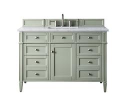Sage green vanity with marble top and drawers.
